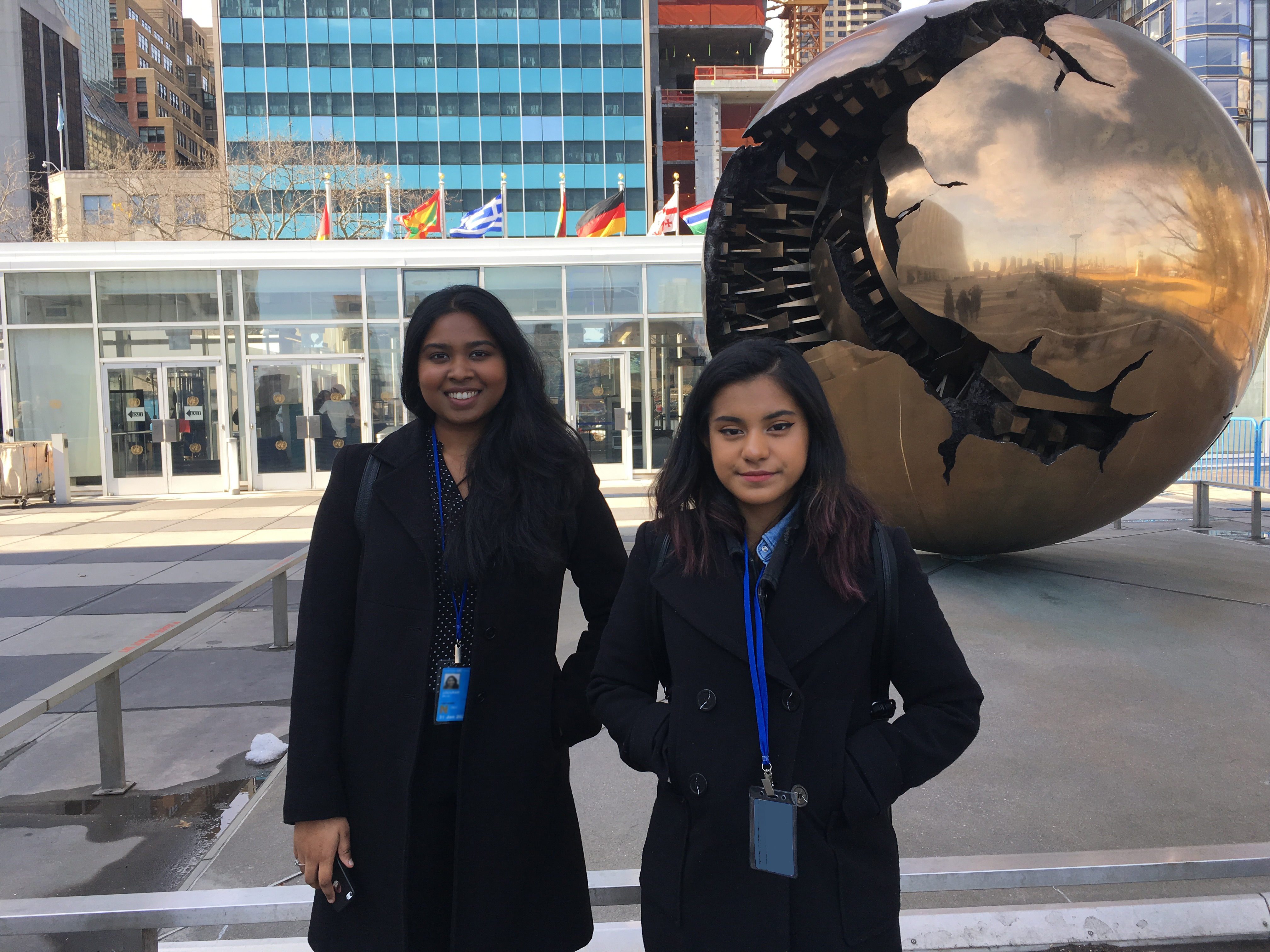 2. Shristi Sookram and Yaritza Bustamante standing in front of Sphere within Sphere by Amaldo Pomodoro at UN Plaza